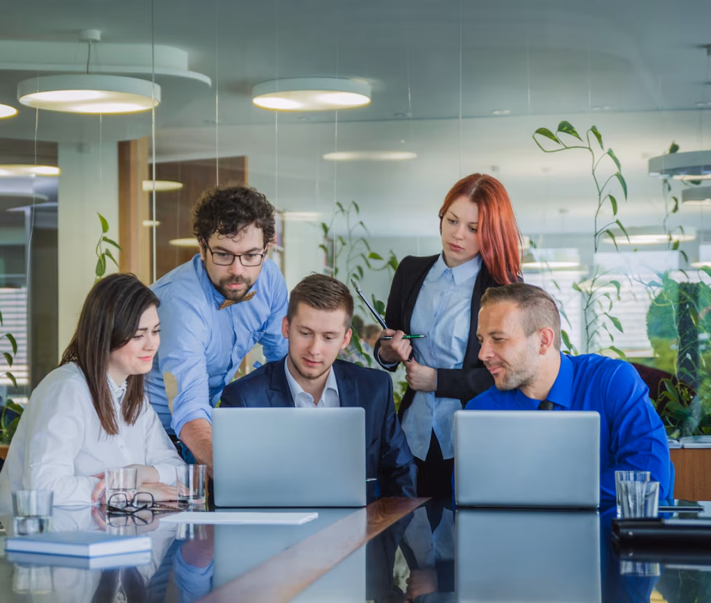 Consulting team reviewing business growth solutions around laptops